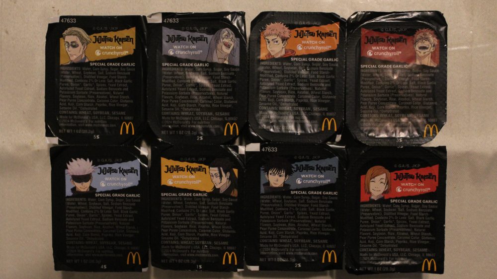 A picture of all 8 Jujutsu Kaisen McDonald's sauce packets. The labeling looks mostly the same except for the color of the top stripe and the characters shown. 