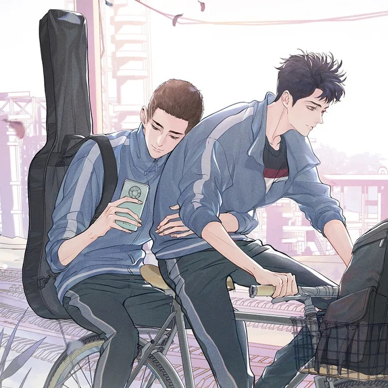 Two boys wearing blue and white school uniforms riding bicycles together. The one in the back has short hair and a guitar slung over his shoulder. He is looking at a smartphone in his hand; a bottom clef is cut into his hair. A backpack is stuck in the front basket.